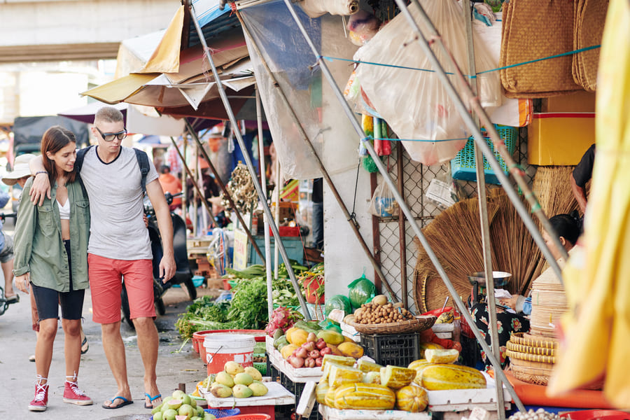 Pareja de turistas abrazados en calles de mercado Chino